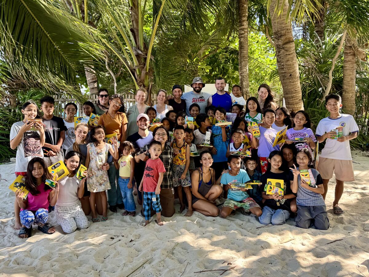 Icosa travelers and local children together during a community program on a beach